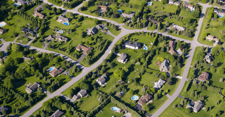 An aerial view of a residential neighborhood with large houses and yards.