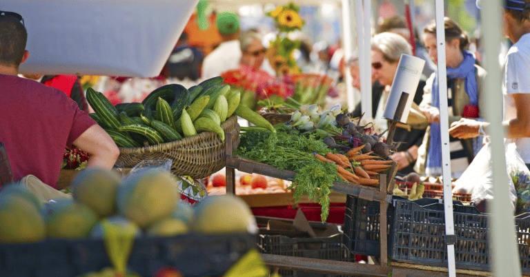 A group of people shopping at a farmers' market.