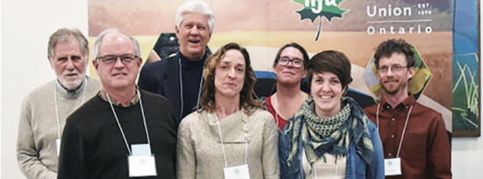 A group of people standing in front of a poster.