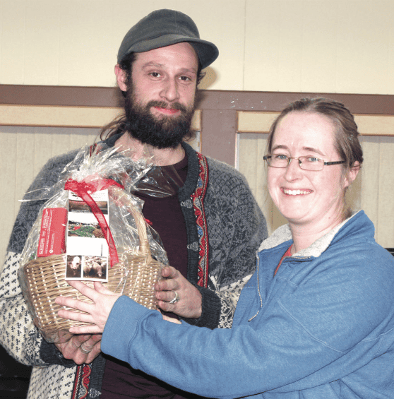 A man with a beard and a woman with glasses holding a basket.