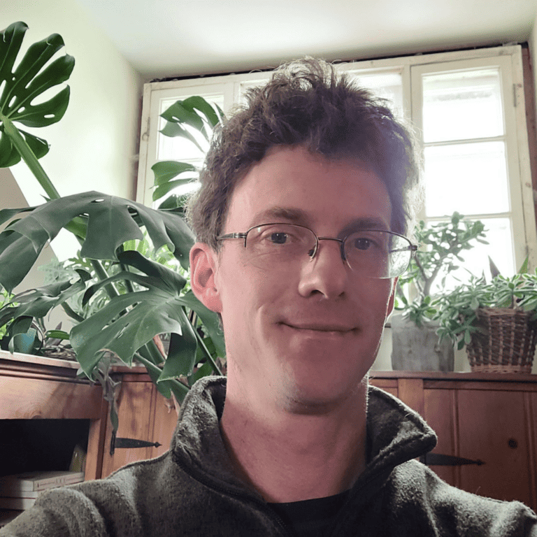 Max Hansgen in front of many potted plants.