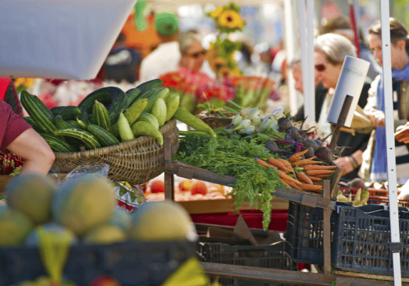 A group of people shopping at a farmers' market.