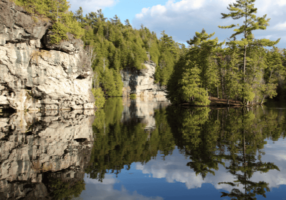 A rocky cliff with trees on a lake in Ontario.