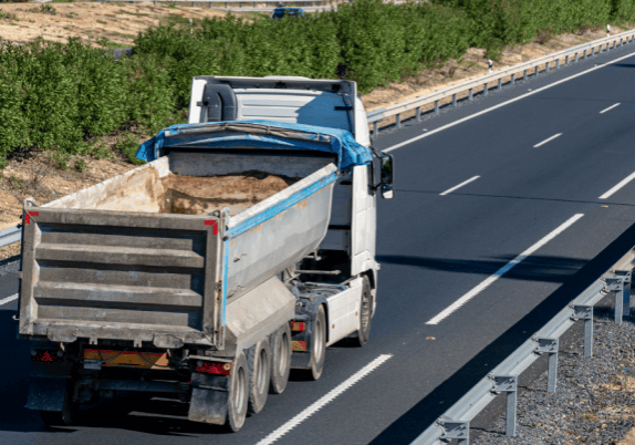 A gravel truck driving down a highway.