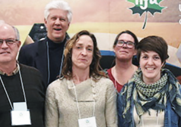 A group of people standing in front of a poster.