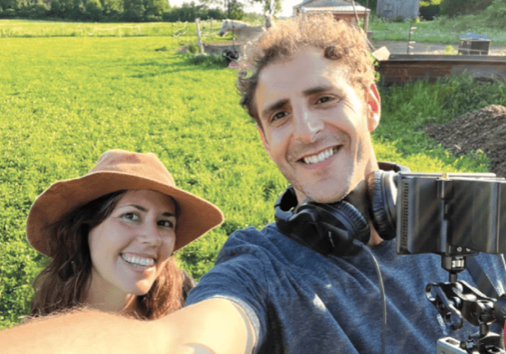 Award-winning documentary filmmakers, Tamer Soliman and Sarah Douglas taking a selfie in a field.